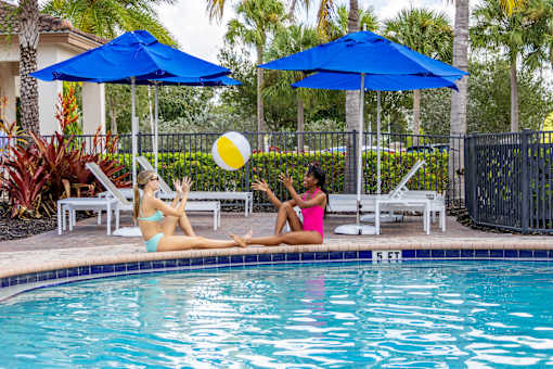 Two women sunbathing by a pool at Portofino Cove, Fort Myers, FL