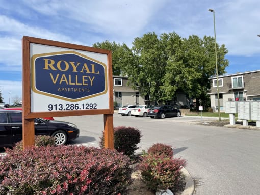 a sign for royal valley apartments in front of a parking lot