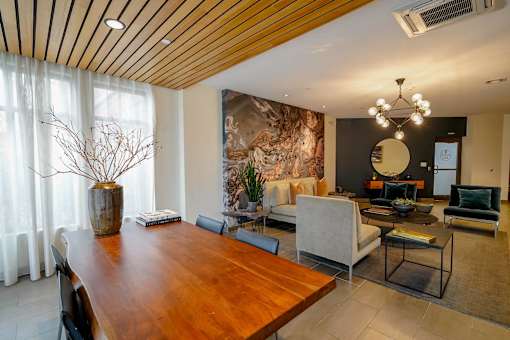 A modern dining room with a wooden table and chairs.