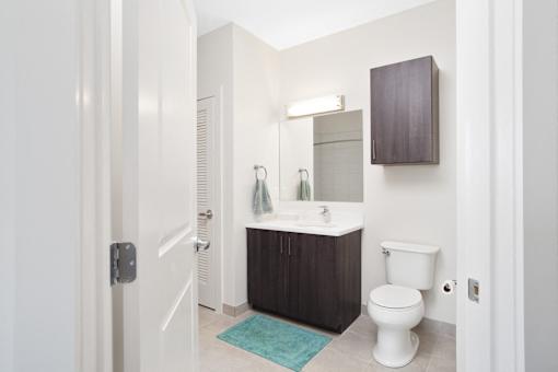 A white toilet sits in a bathroom next to a sink.
