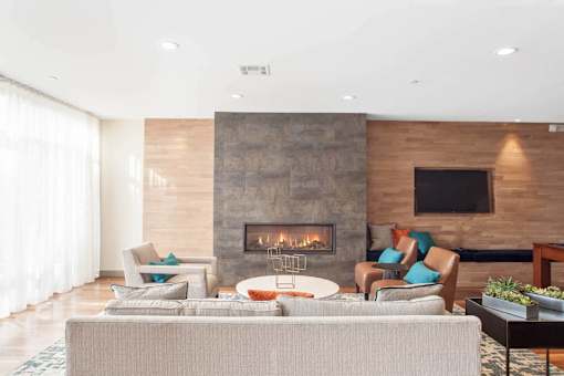 A modern living room with a fireplace and a flat screen TV mounted on the wall.