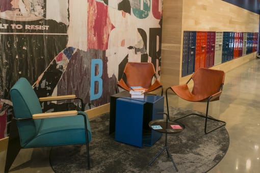 a group of chairs and a table in the lobby of a building with a mural