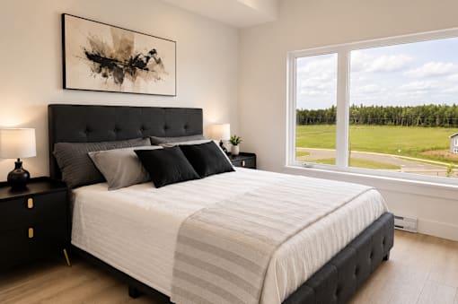 A bedroom with a large bed and a painting on the wall.