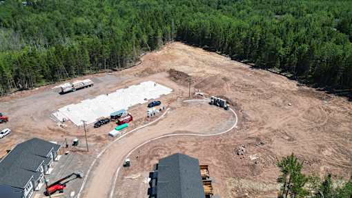 A construction site with a large open area and a few buildings.