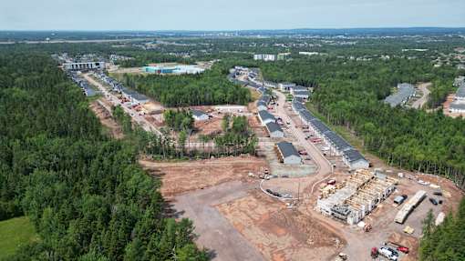 An aerial view of a construction site surrounded by trees.