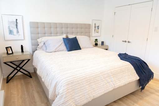 A bed with a white comforter and a blue pillow is in the image.