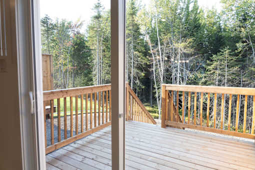 A wooden deck with a view of a forest.