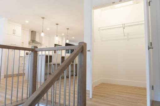 A white room with a wooden floor and a white wall with a door.