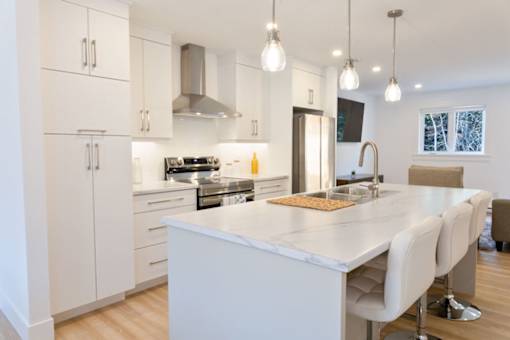 A modern kitchen with white cabinets and a large island.
