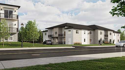 A modern apartment complex with a car parked in front.