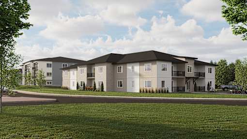A modern apartment complex with a grassy front yard.