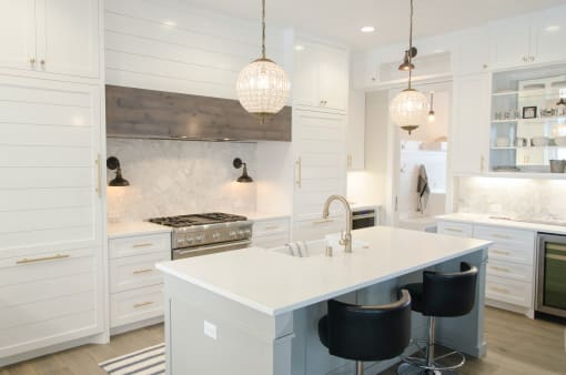 a large kitchen with white cabinets and a white counter top