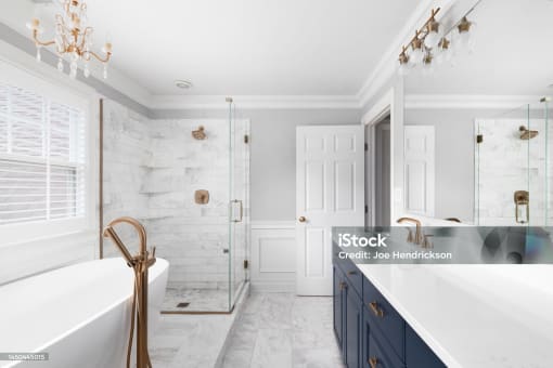 a white and blue bathroom with a tub and a shower and a sink