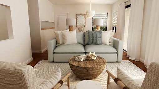 A living room with a light blue couch, a wooden coffee table, and a white chair.