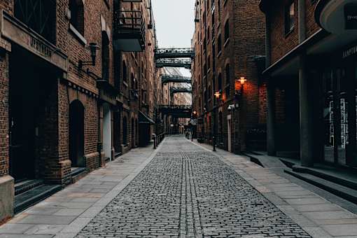 an empty street with buildings and a bridge
