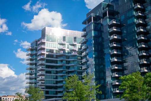 a tall glass building with trees in front of it