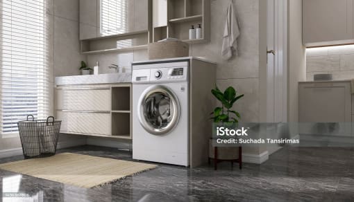 a washing machine in a kitchen with a sink and a window