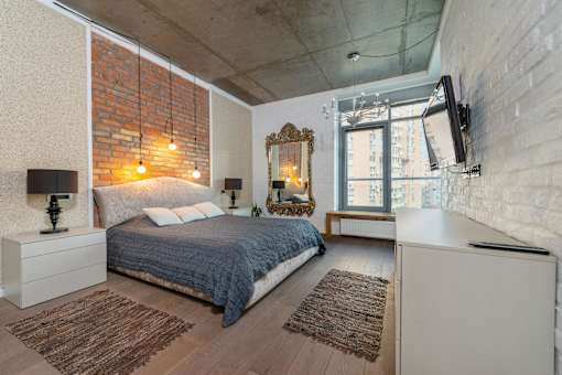 A bedroom with a bed, a dresser, and a mirror.