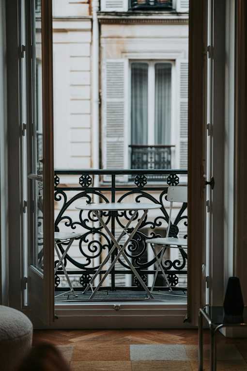 a room with a balcony and a view of a building and a balcony door