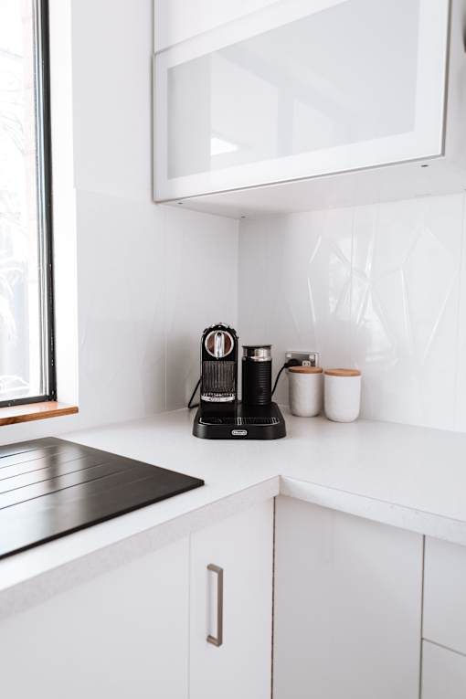 coffee maker on white counter with white cabinets