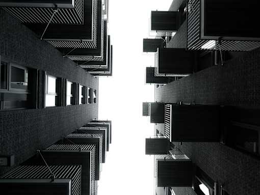 ground to sky view of apartment balconies from underneath