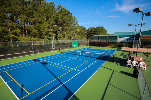 a tennis court with blue and green courts and a fence