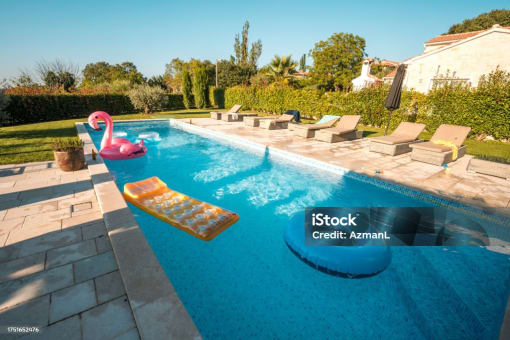 Community pool with lounge furniture and pool toys