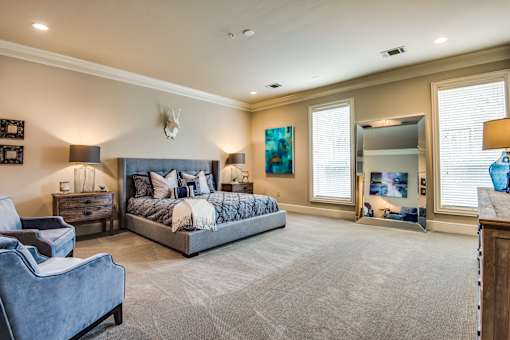 A bedroom with a large bed and a couch.