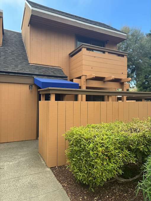 A house with a brown facade and a blue awning.