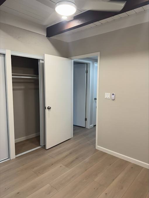 A room with a white door and a white wall with a switch.