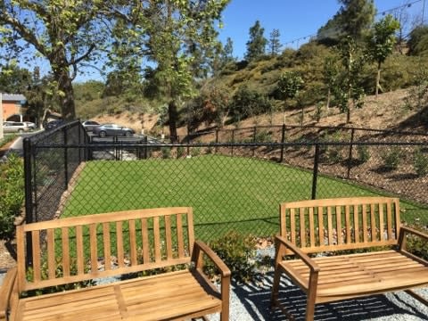 a backyard with two wooden benches and a chain link fence