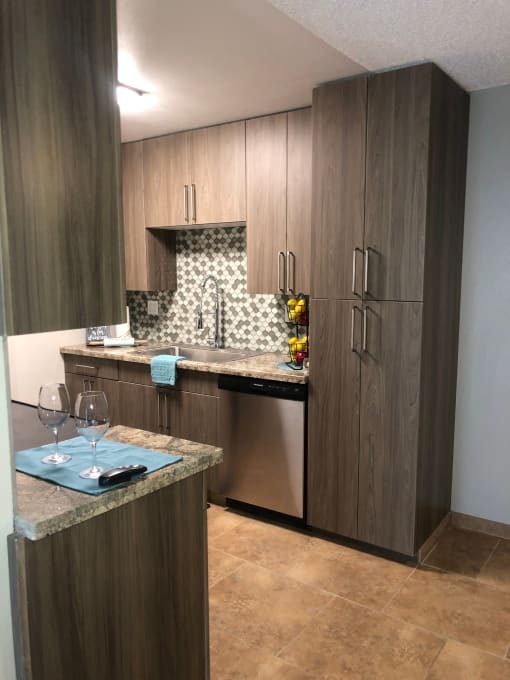 a kitchen with wooden cabinets and a marble counter top