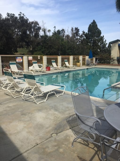 a swimming pool with chairs and chairs around it
