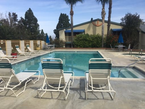 a swimming pool with beach chairs around it