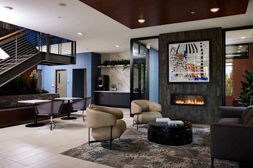 A modern living room with a fireplace and a staircase.