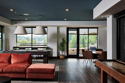 A modern living room with a red couch and a dining table.