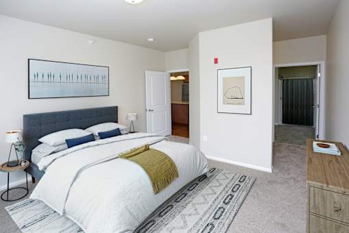 A bedroom with a large bed and a painting on the wall.