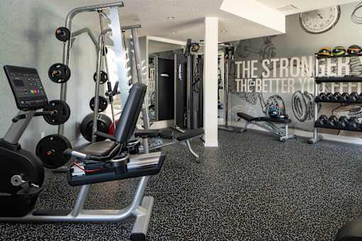 A gym with a variety of equipment including weights and a treadmill.