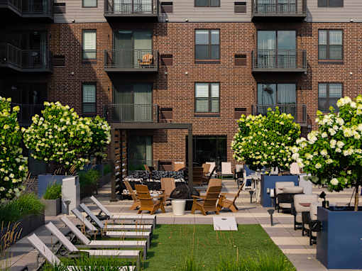 Apartment building with a patio and chairs.