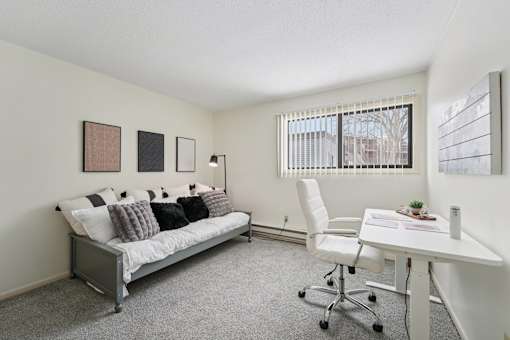 Room with desk, chair and white couch at The Bosk Apartment Homes, Woodbury, MN, 55125
