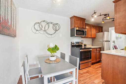 A kitchen with a table and chairs and a fridge.