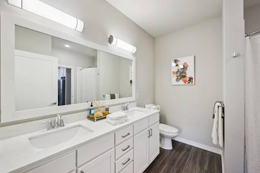 A white bathroom with a white sink and a white toilet.