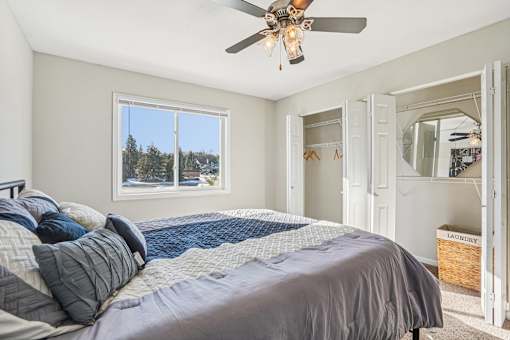 A bedroom with a large bed and a ceiling fan.