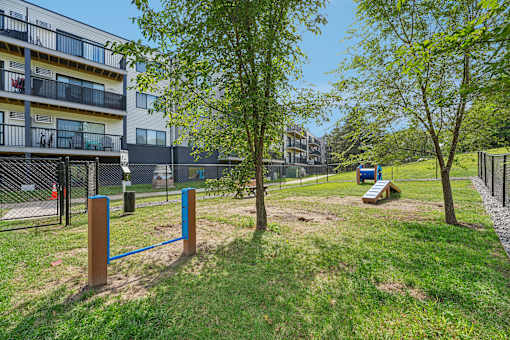 A playground with a blue swing set and a brown pole in the foreground.