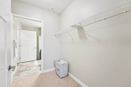 A white room with a white shelf and a white box on the floor.