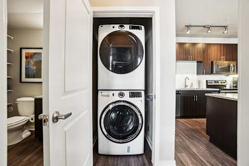 A white front loading washing machine in a small room.