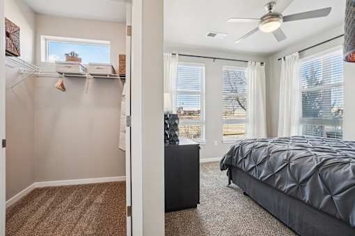 A bedroom with a large bed and a ceiling fan.