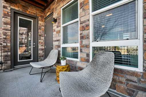 Two grey chairs are placed on a patio.