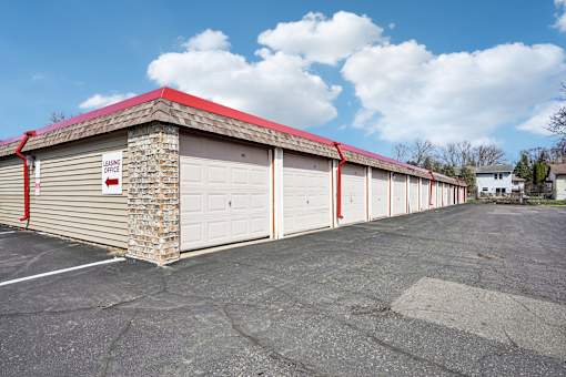 A parking lot with a building that has a red roof and a sign that says "No Parking".