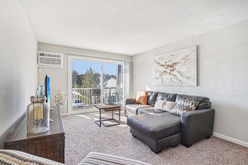 A living room with a couch, a coffee table, and a painting on the wall.